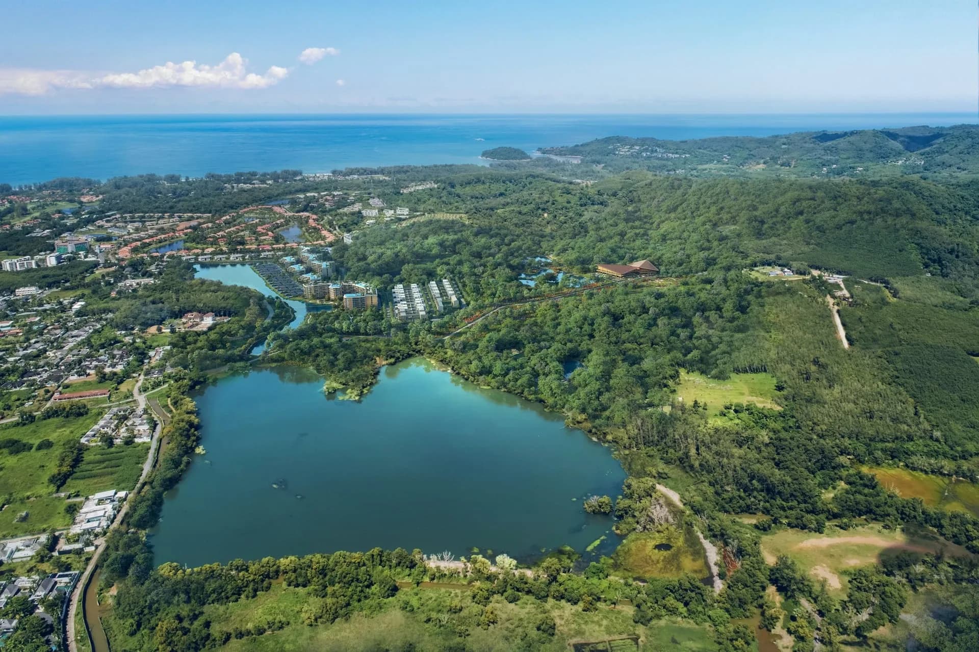 Aerial photograph of the Laguna Lakelands lake, forested hills and Bang Tao coastline in the distance